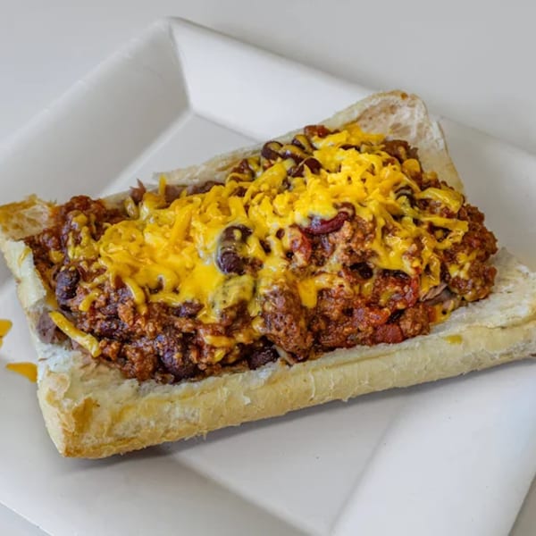 Unbeatable Eatables' chili cheese sandwich, a hearty sub roll overflowing with meaty chili and melted cheddar.