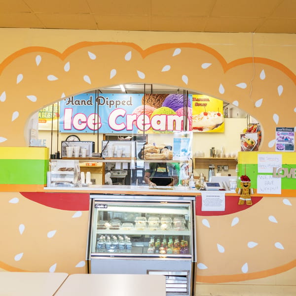 A colorful counter at Unbeatable Eatables with an ice cream sign, display case, and sandwich-themed decor.